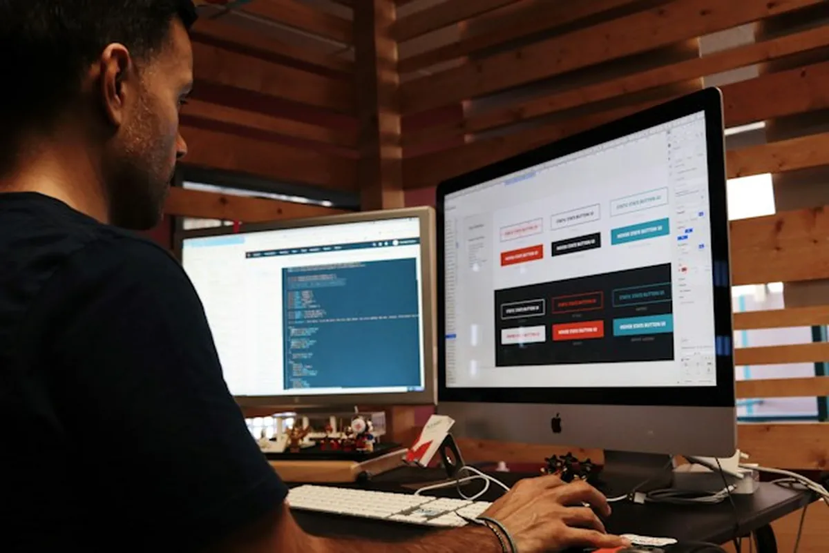 İzmir kurumsal web tasarım: iki ekranda kod ve arayüz bileşenleri üzerinde çalışan tasarımcı